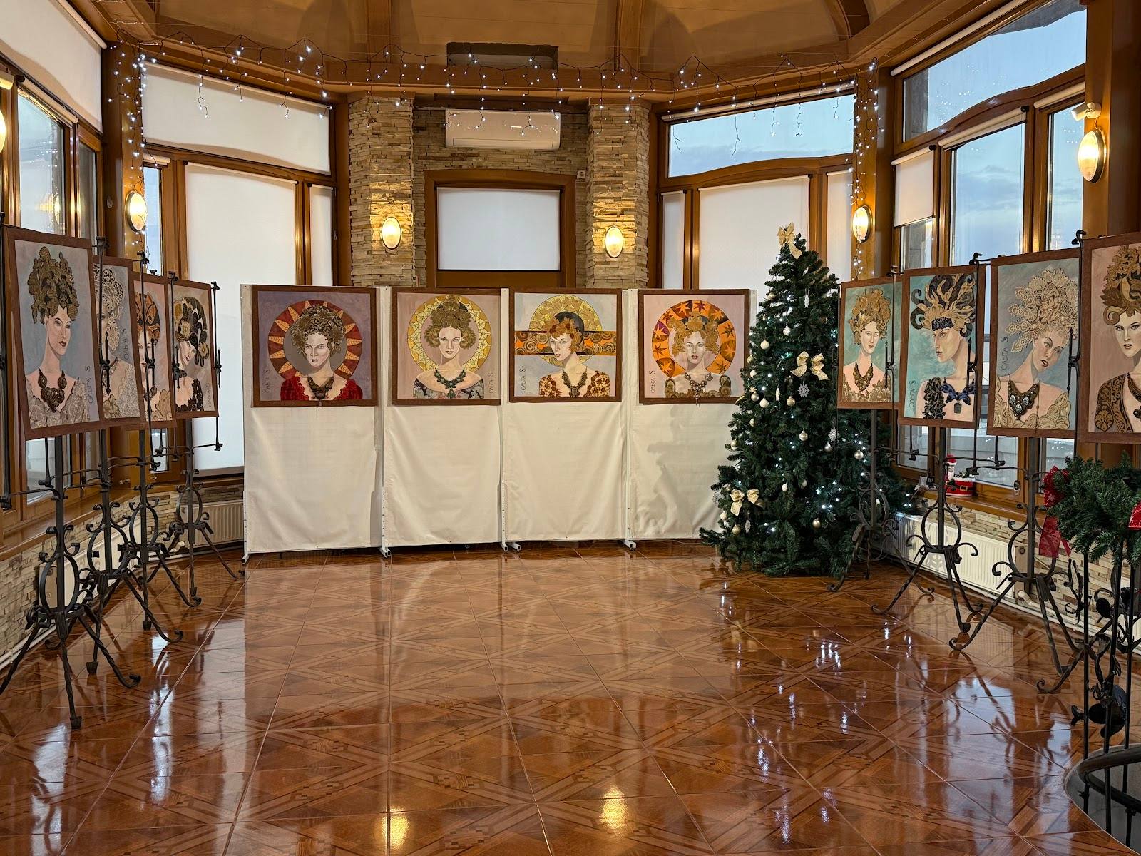 Historic salon interior with ornate windows, wooden floors, and contemporary art display