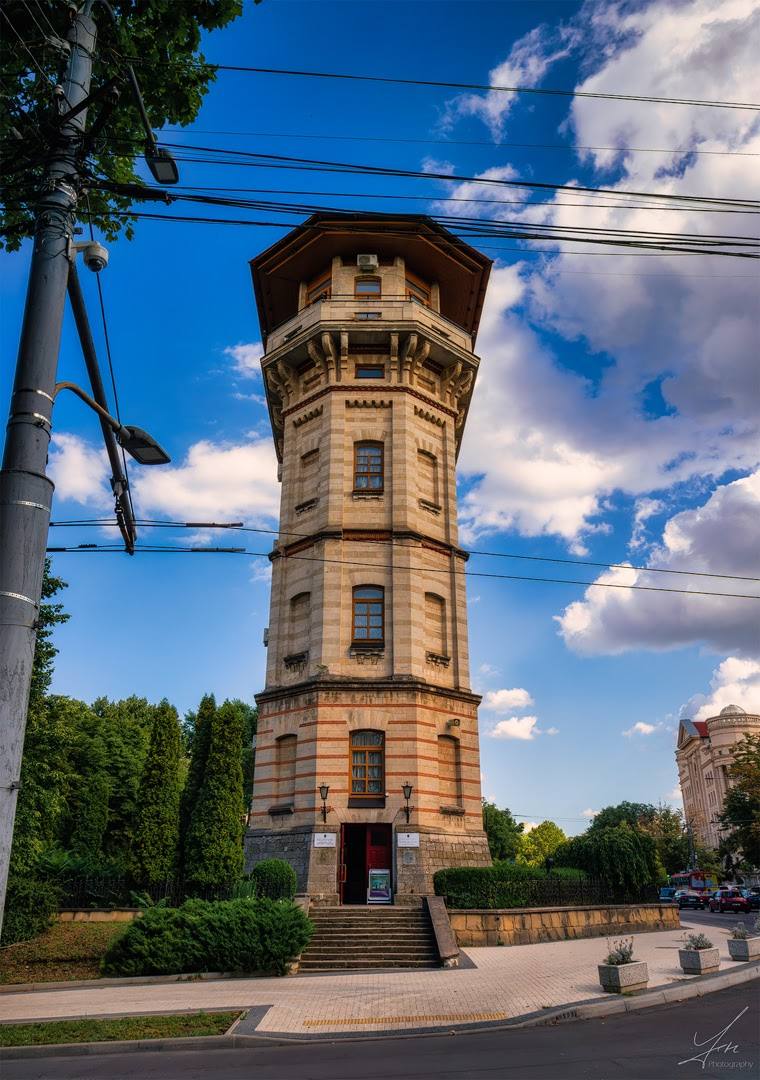 Historic octagonal stone tower with ornate architecture under clear blue sky