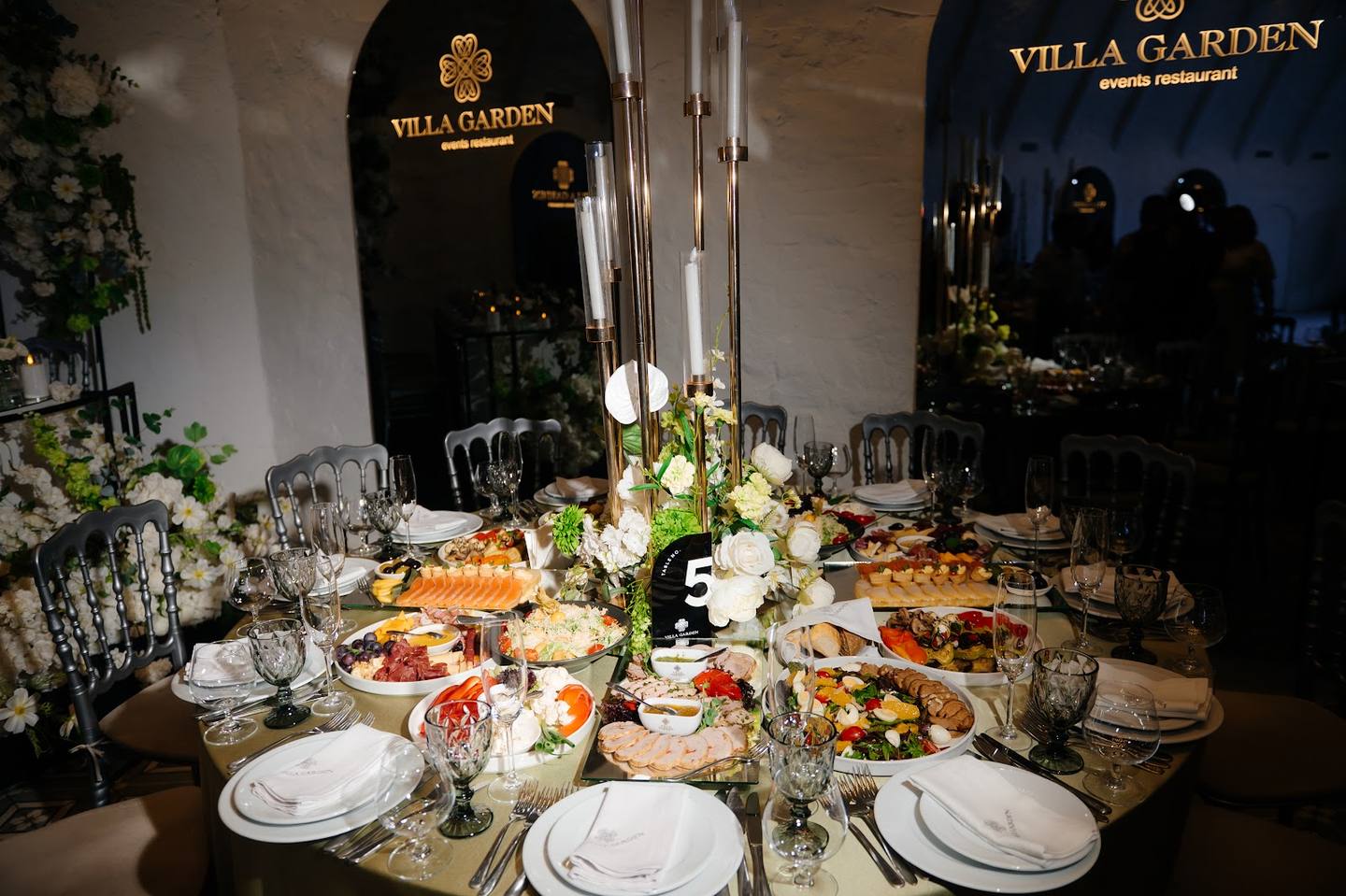 Elegantly styled banquet table with floral arrangements and Villa Garden branding visible