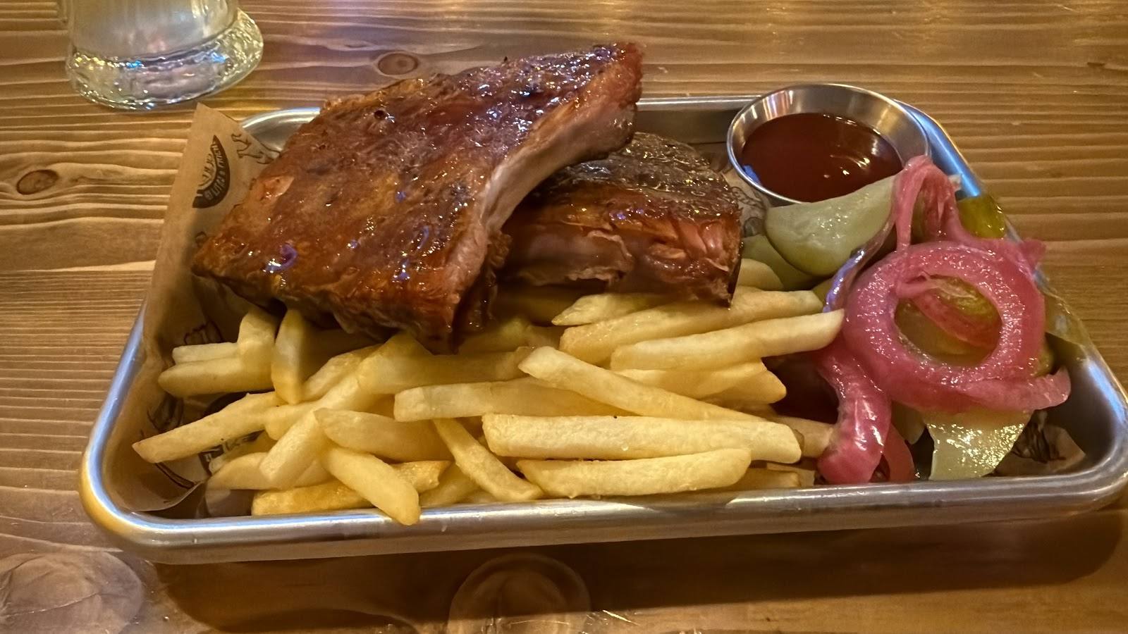 Roasted chicken with golden fries and side dishes on a metal tray