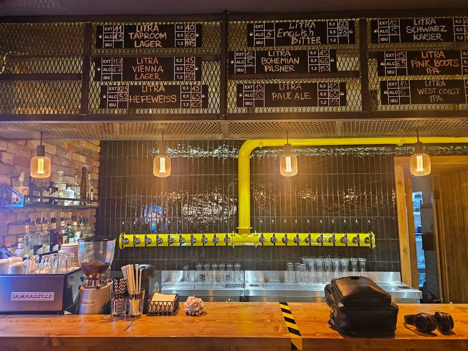 Modern cafe counter with yellow neon sign and wooden-paneled bar area