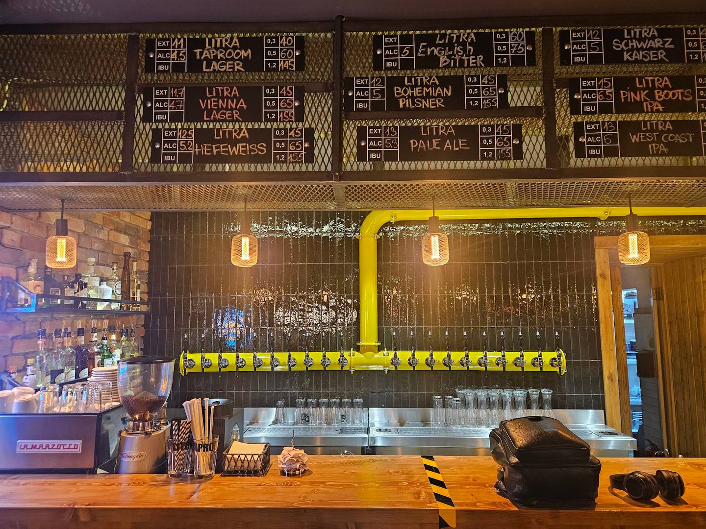 Modern cafe counter with yellow neon sign and wooden-paneled bar area