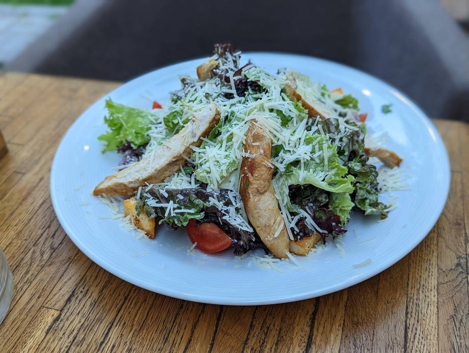Gourmet salad with seared mushrooms, greens, and shaved cheese on white plate
