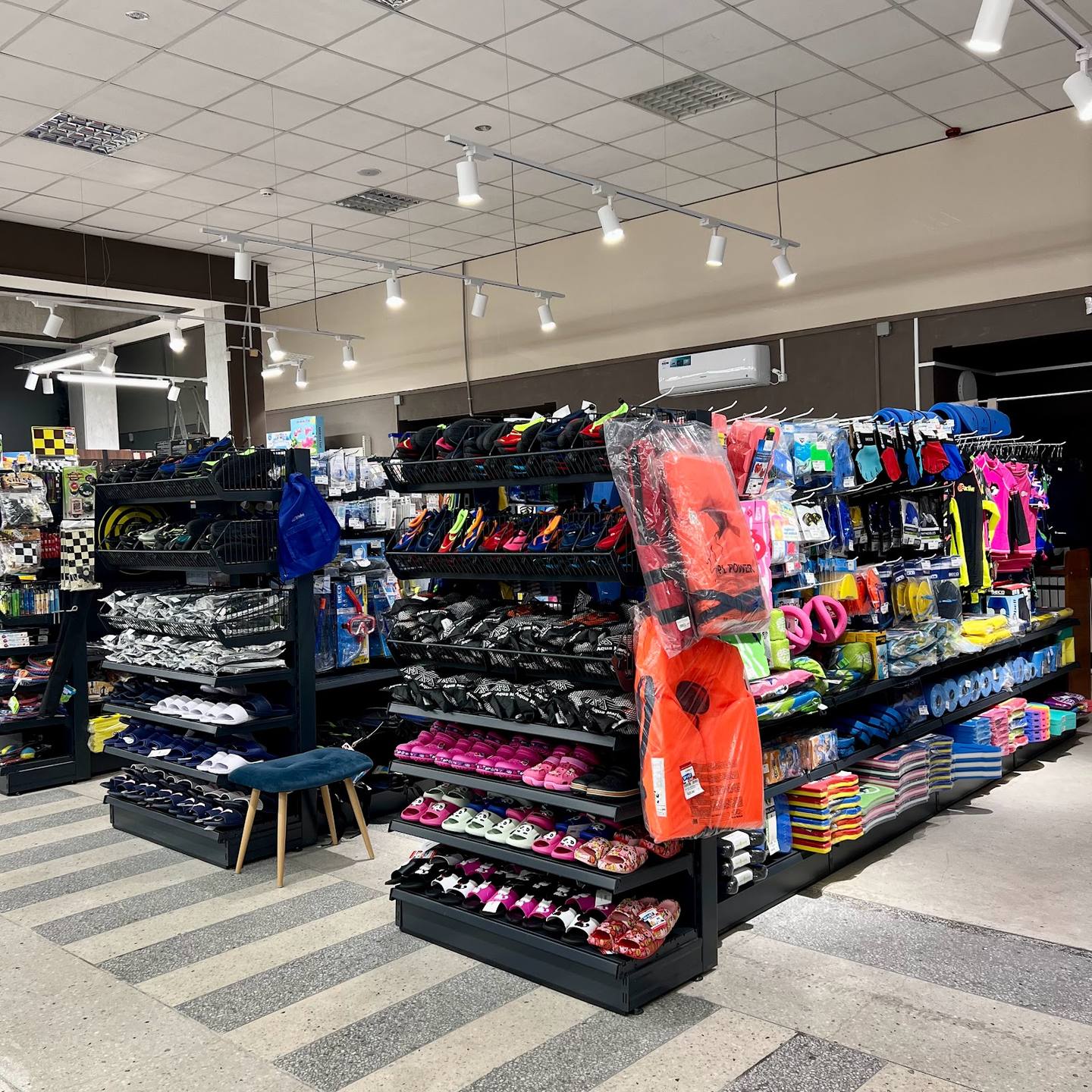 Bright retail sports apparel and activewear showroom with display tables and colorful merchandise.