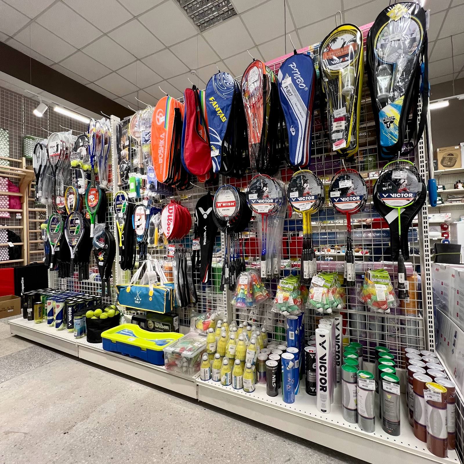 Sports equipment and water gear retail display wall with surfboards, wetsuits, and accessories