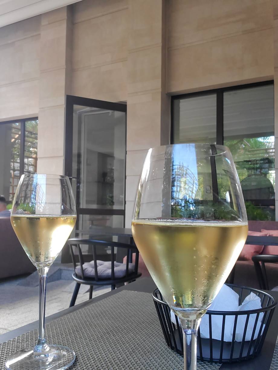 White wine glasses on a terrace with modern facade and black furniture