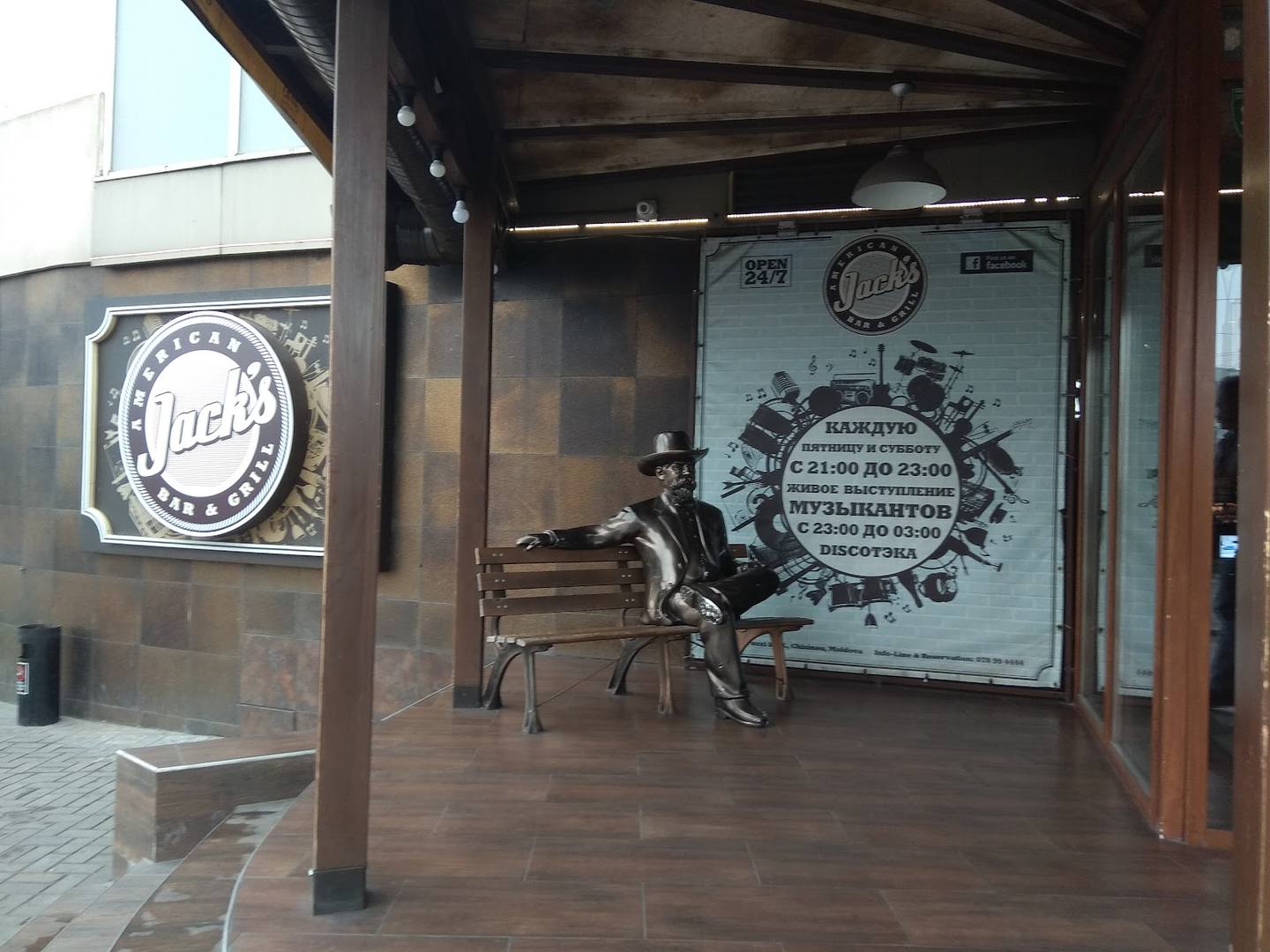 Covered terrace entrance with branded signage and sculptural detail