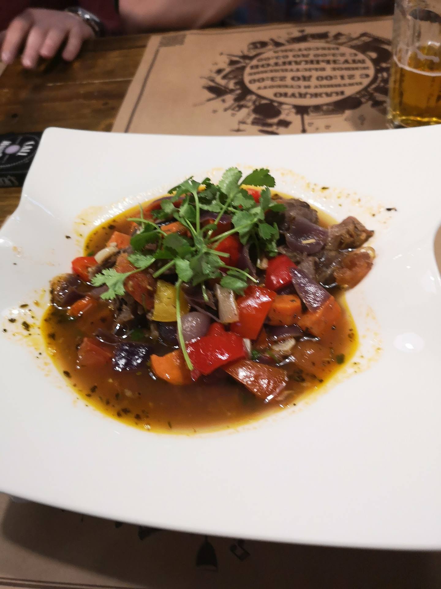 Sautéed beef with roasted vegetables and microgreens in rich sauce