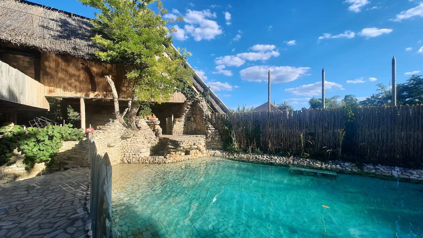 Cenote with turquoise water and stone architecture amid lush vegetation