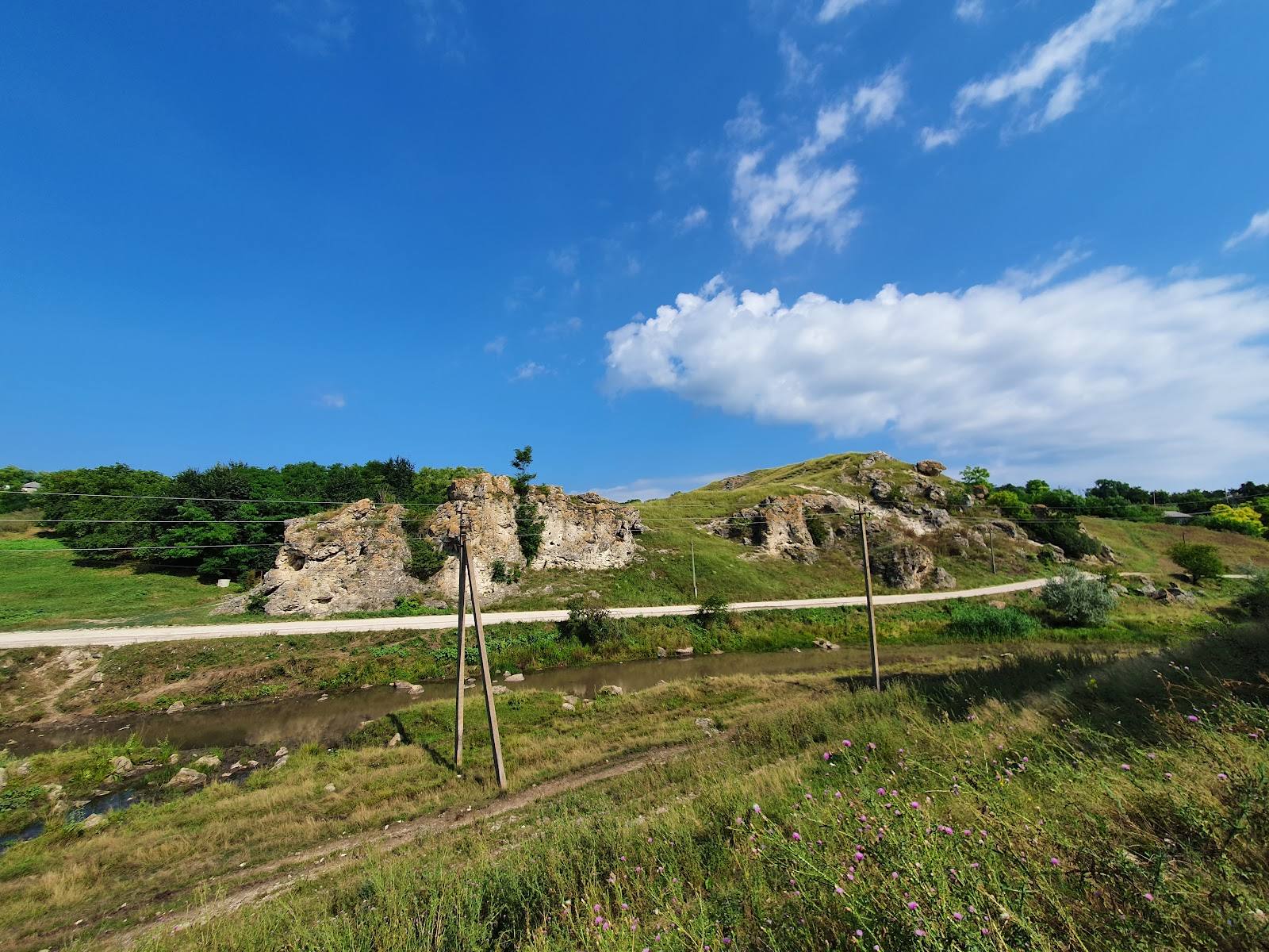 Ancient fortress ruins set on a green hillside under clear sky