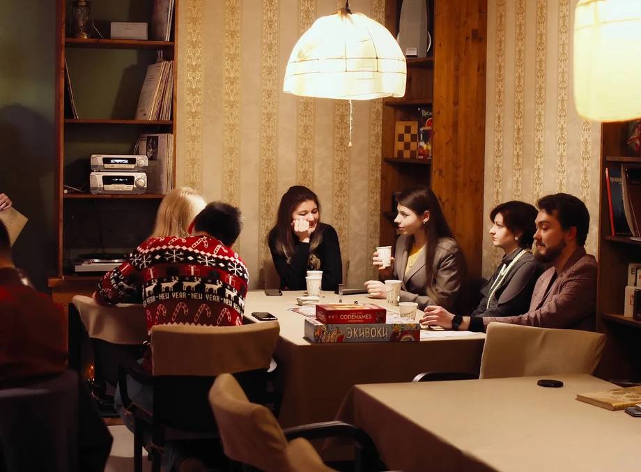 Meeting or event gathering in an interior space with warm lighting and modern furnishings