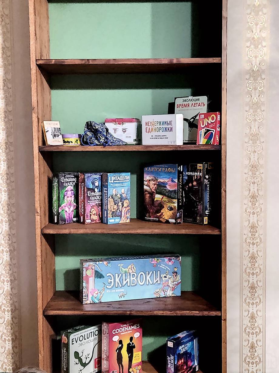 Board game and merchandise display shelf with painted green background