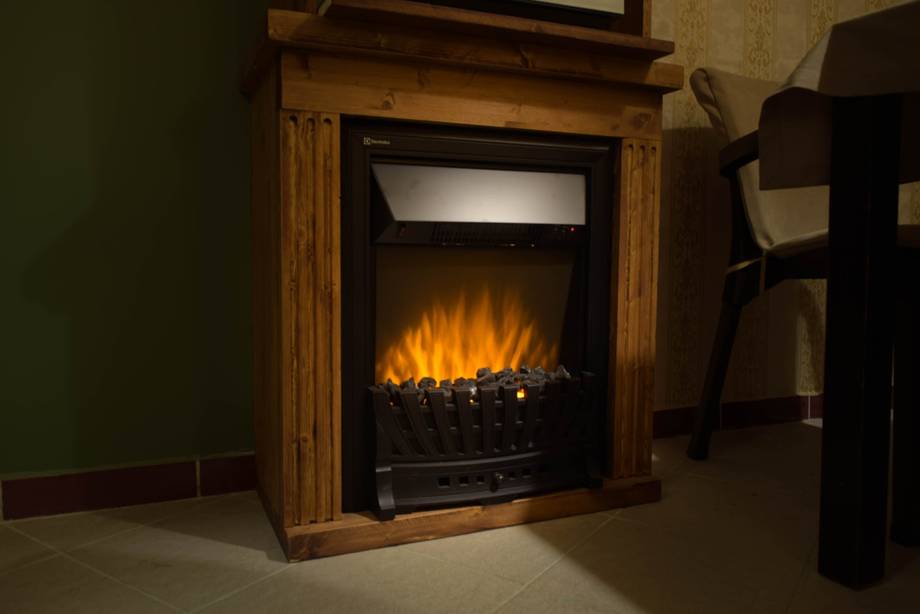 Electric fireplace with wooden surround in ambient lighting