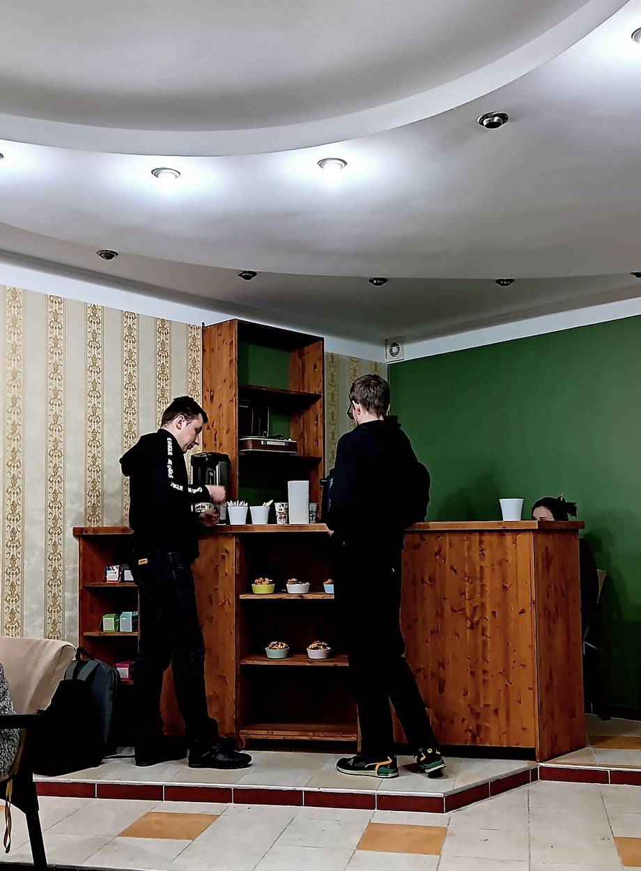 Cafe or tea house interior with wooden service counter and green accent wall