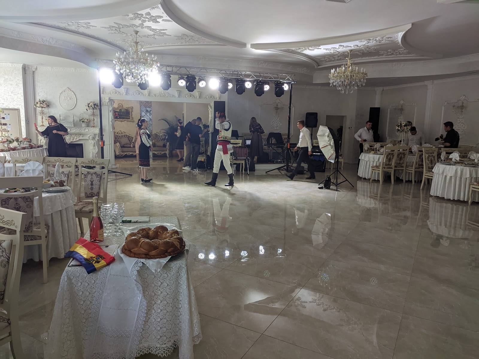 Elegant banquet hall with white table settings and crystal chandeliers prepared for wedding reception