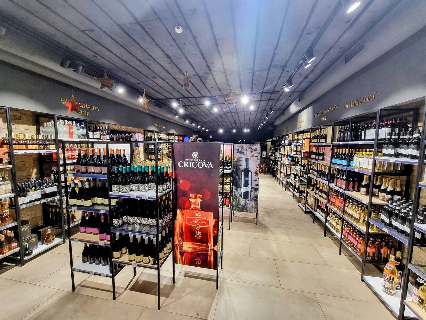 Wide-angle view of modern wine and spirits retail store with organized shelving and product displays