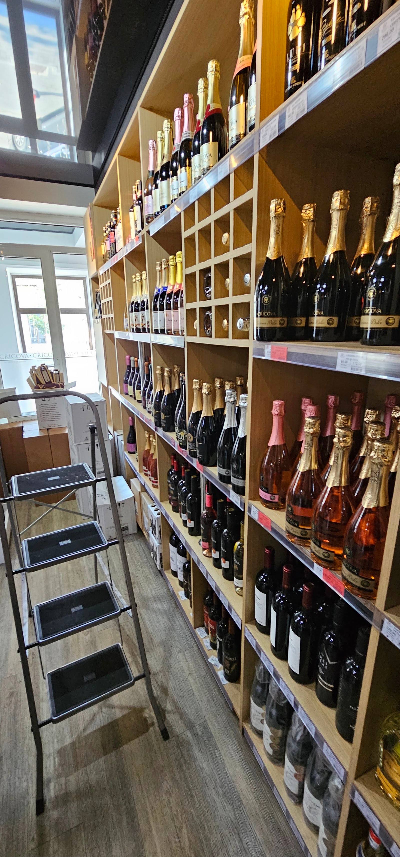 Wine shop interior with floor-to-ceiling bottle display and natural skylighting