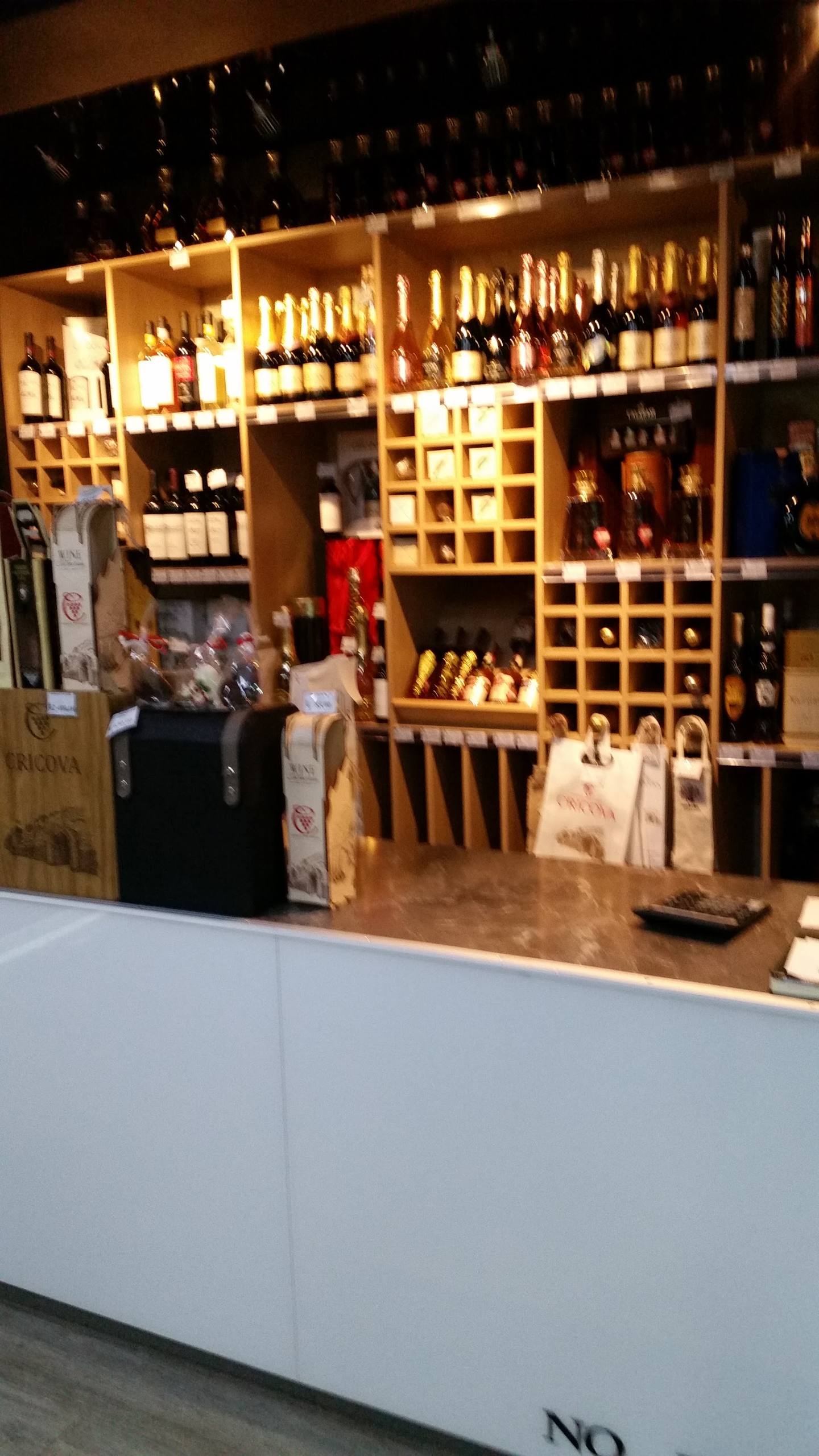 Wine shop interior with illuminated bottle display and wooden wine racks