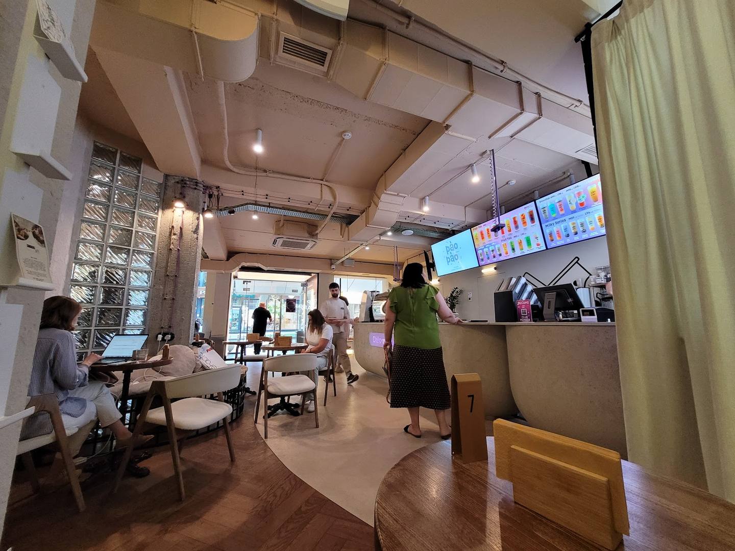 Modern cafe interior with counter service, casual seating, and menu displays