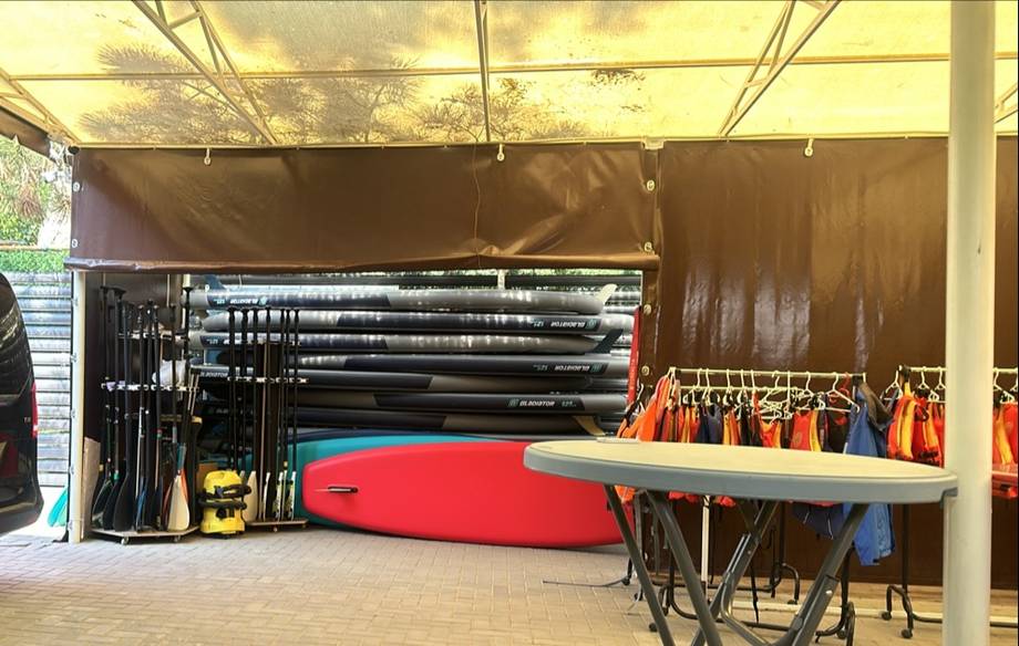 Water sports equipment storage area with paddleboards and kayaks