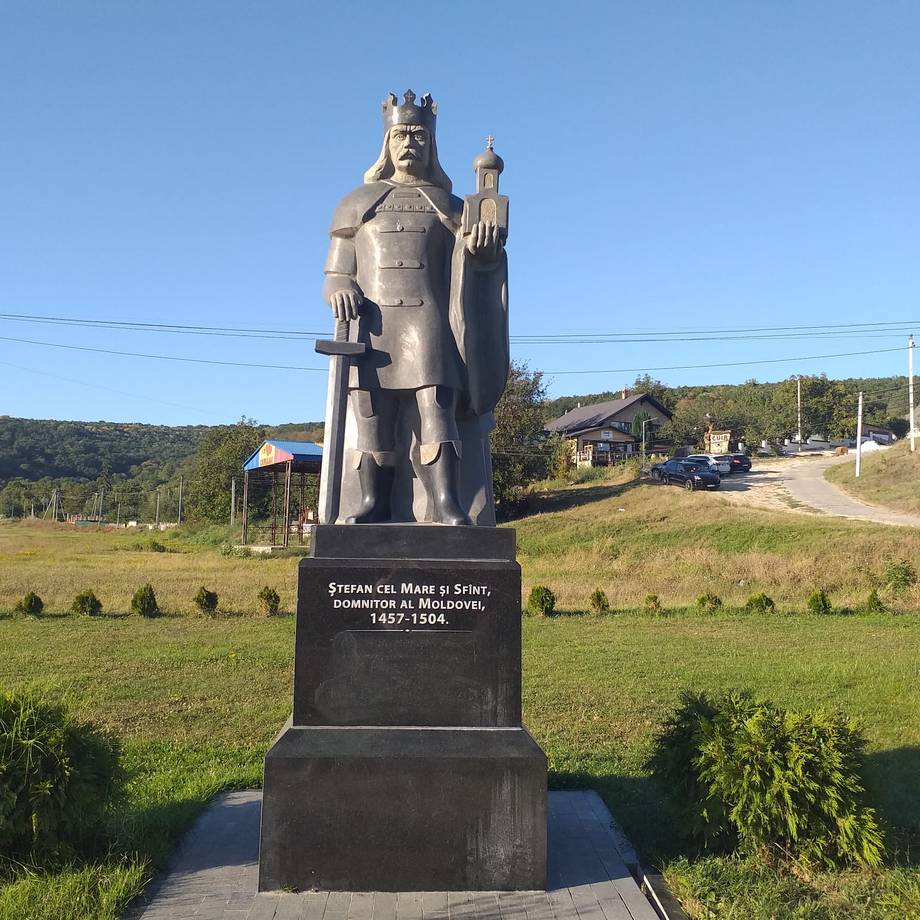 Historic stone monument statue of a medieval Moldovan ruler in rural countryside setting