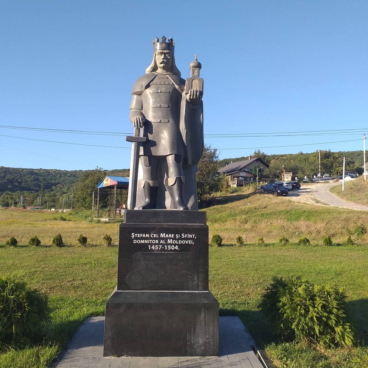 Historic stone monument statue of a medieval Moldovan ruler in rural countryside setting