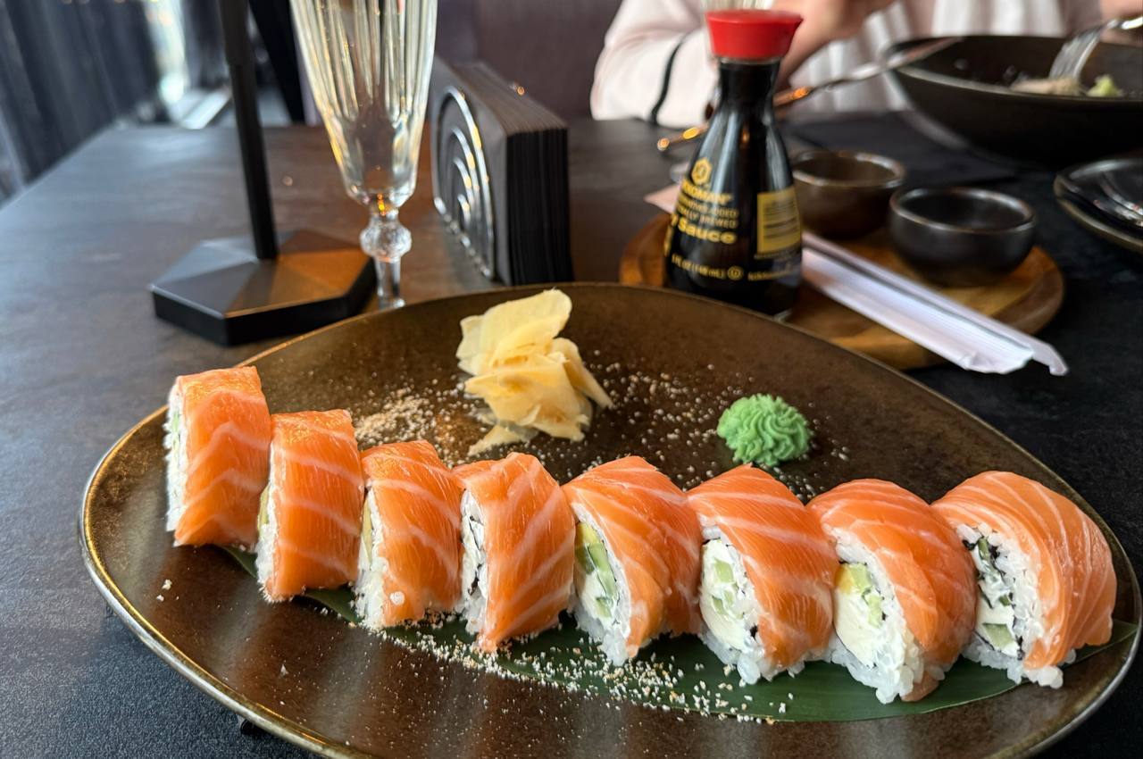 Beautifully plated nigiri sushi with salmon and white fish on dark ceramic plate