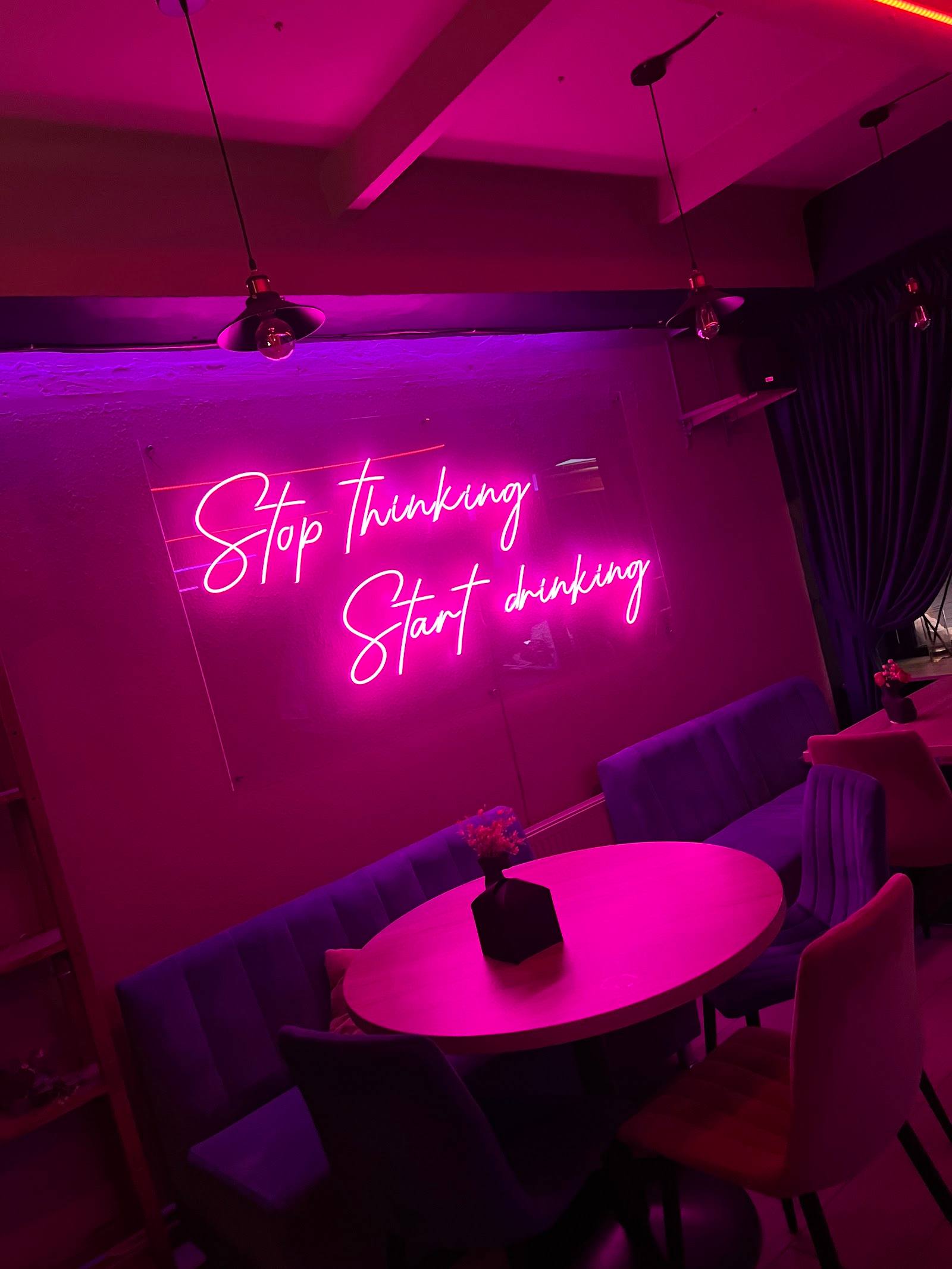 Modern lounge interior with neon signage and ambient purple lighting