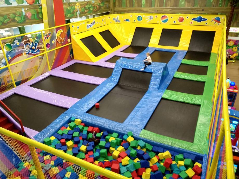 Colorful trampoline park with ball pit and foam platforms in children's activity center