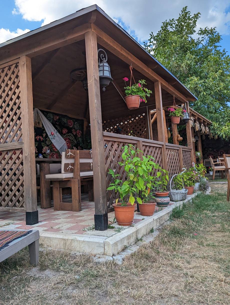 Wooden terrace pavilion with potted plants and garden seating area