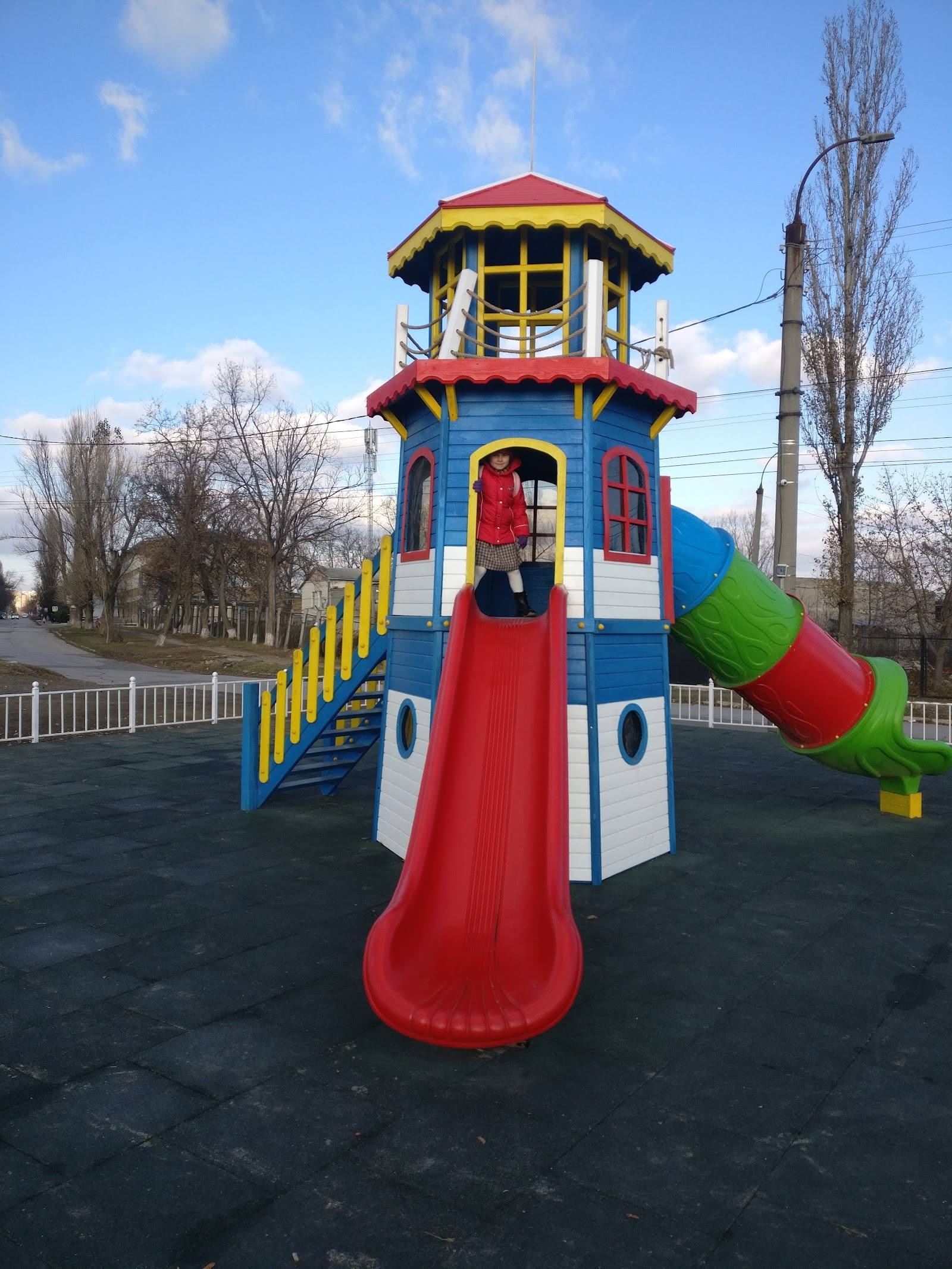 Colorful children's playground tower with slides and climbing features in outdoor park setting