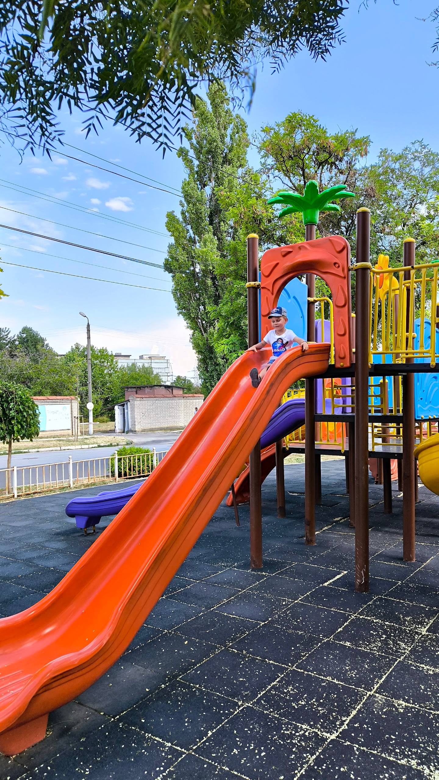Colorful playground with orange slide and equipment in outdoor setting