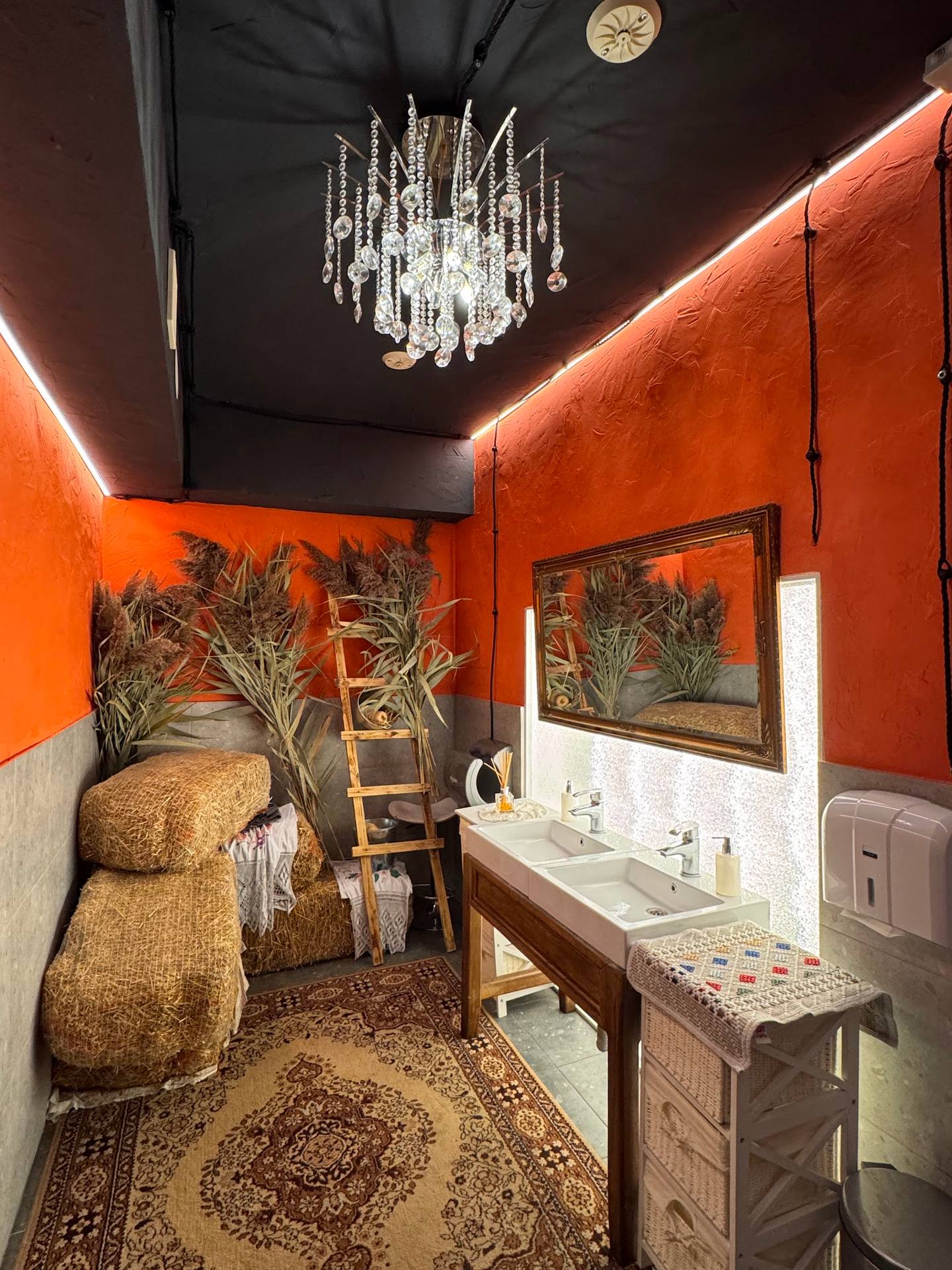 Luxurious spa bathroom with orange accent walls and crystal chandelier
