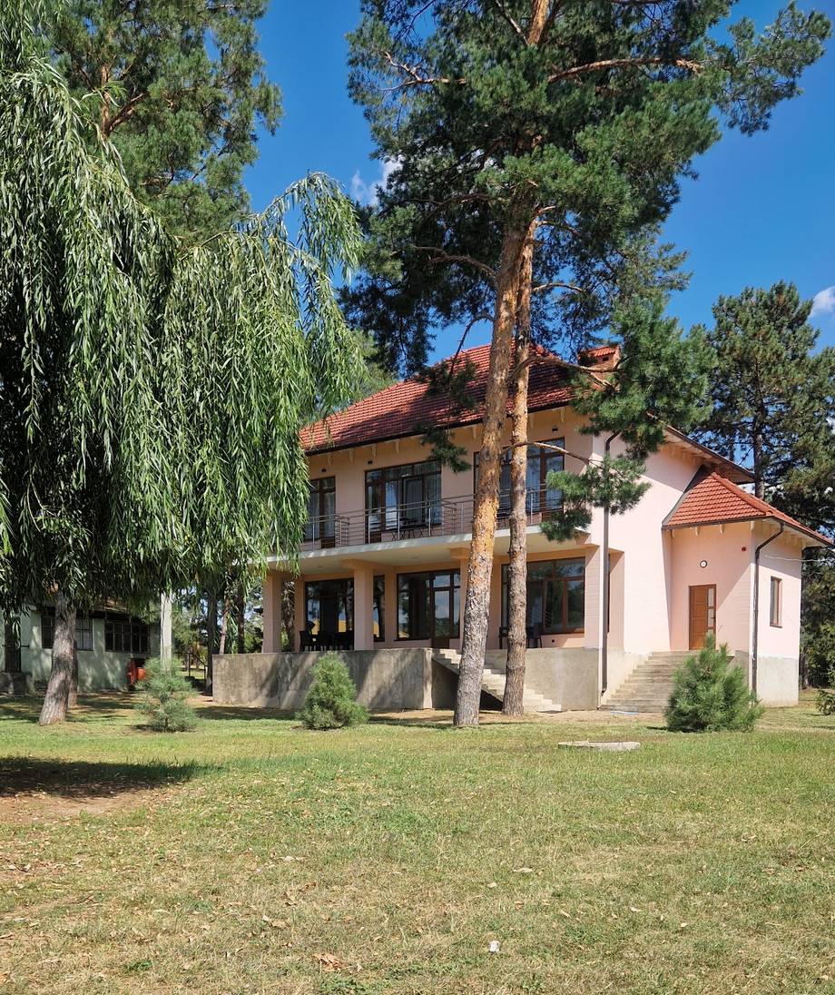Charming two-story country estate with terracotta roof and mature trees on manicured grounds