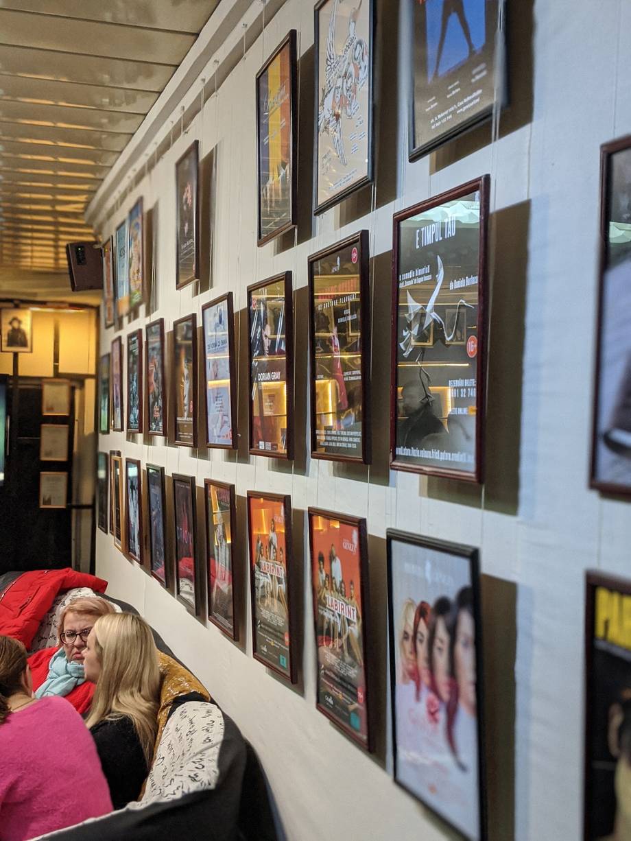 Interior wall display with framed event posters and photos under warm gallery lighting