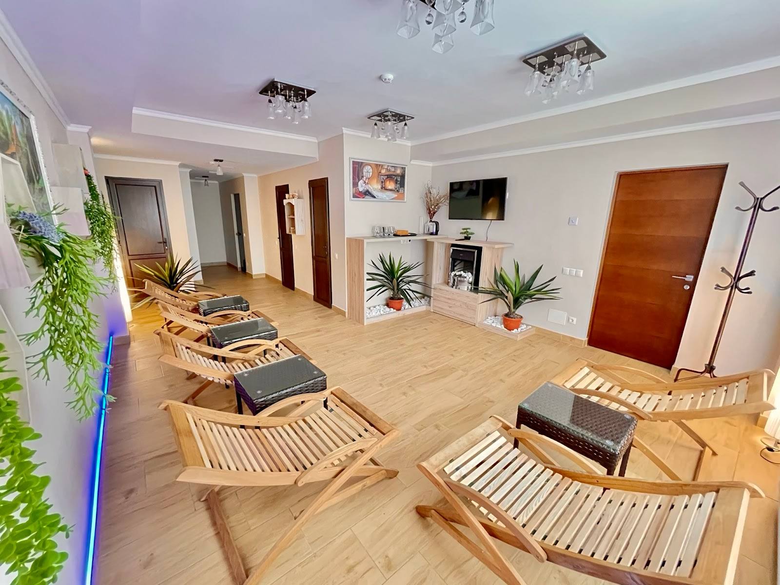 Wellness spa treatment room with wooden loungers, plants, and soft ambient lighting
