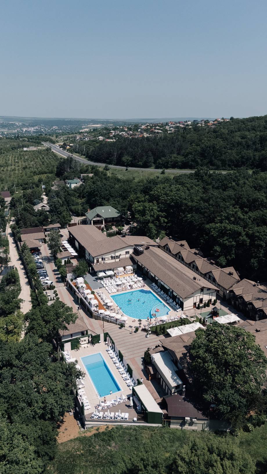 Aerial view of resort with Olympic-size swimming pools surrounded by forested hills