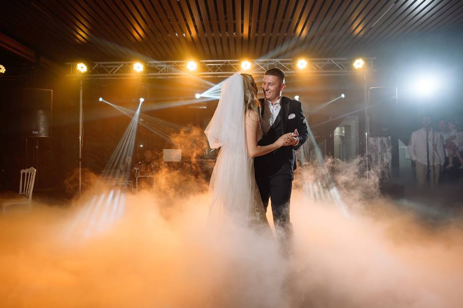 Bride and groom first dance with dramatic fog and stage lighting