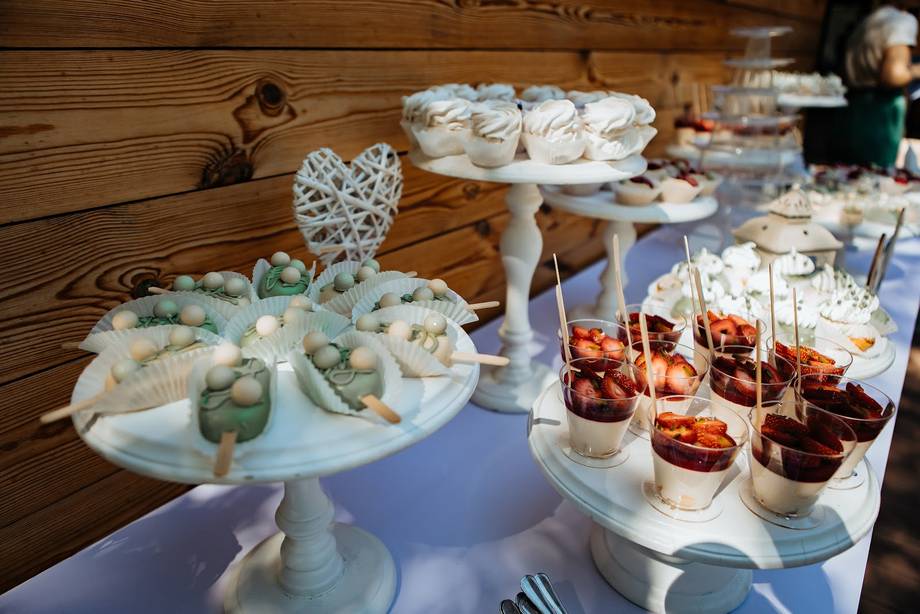 Elegantly arranged dessert and appetizer display on wooden table with tiered stands