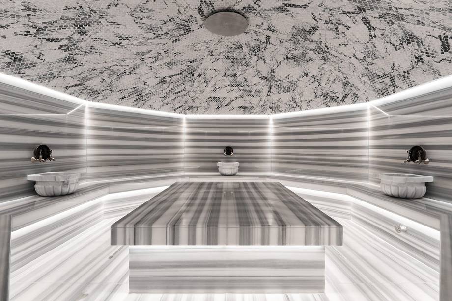Modern spa sauna interior with striped wooden benches and neon ceiling lighting