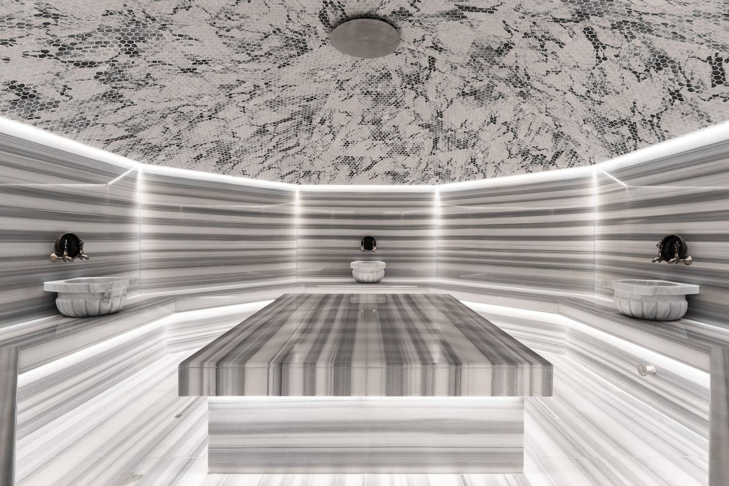Modern spa sauna interior with striped wooden benches and neon ceiling lighting