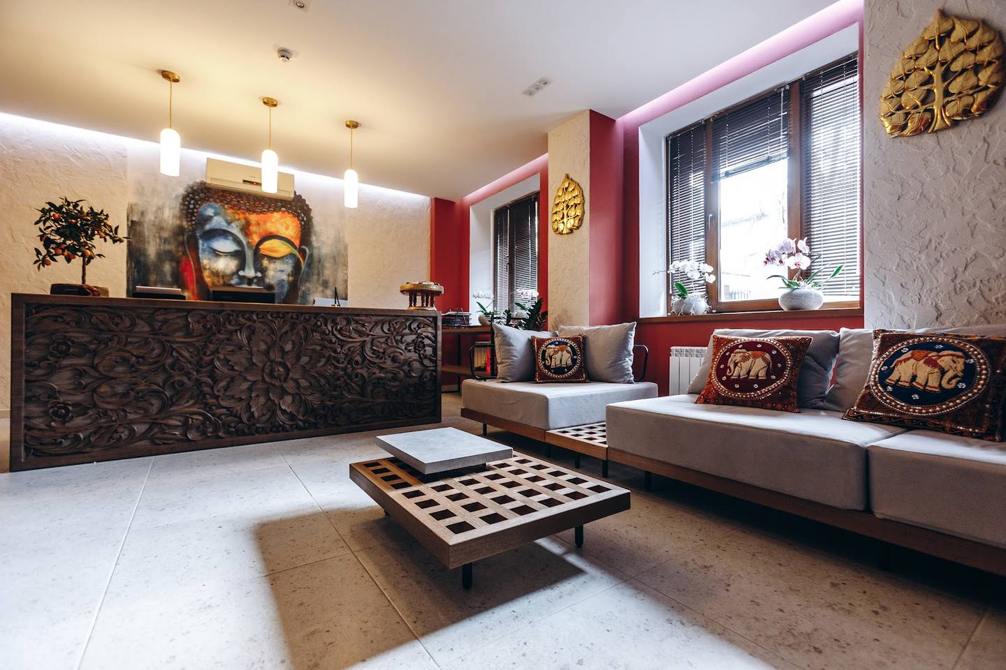 Modern upscale lounge with burgundy accent walls, designer seating, and ambient lighting