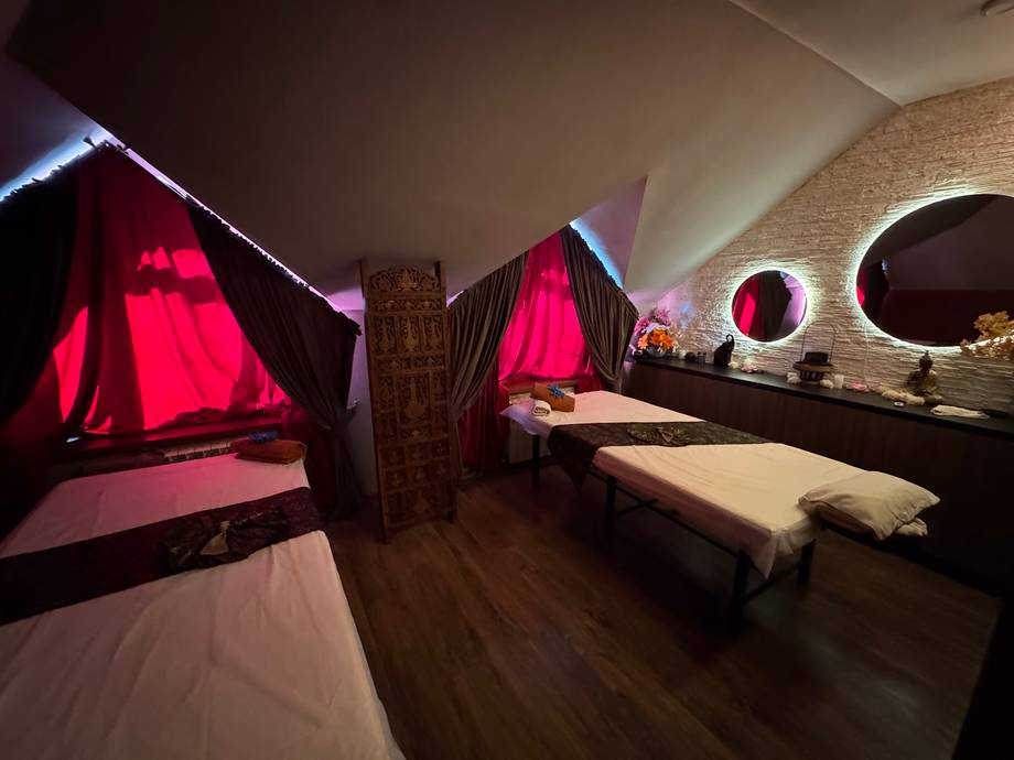 Spa treatment room with illuminated red fabric canopies and massage tables