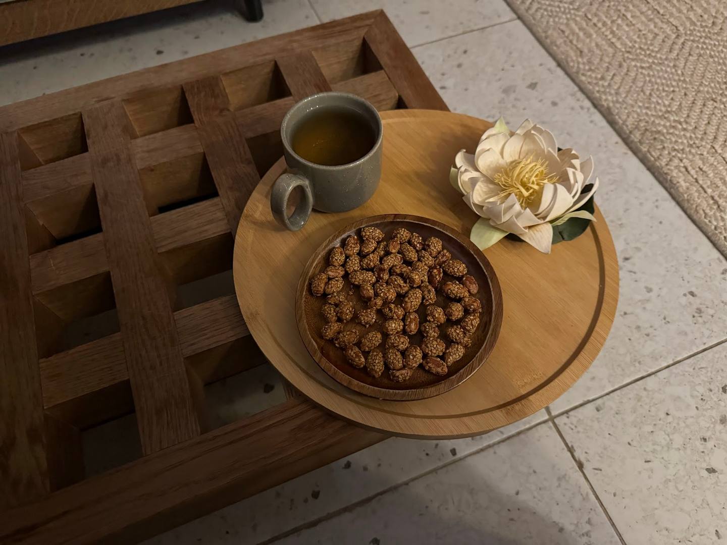 Overhead table styling with cereal bowl, coffee cup and white flower on wooden tray