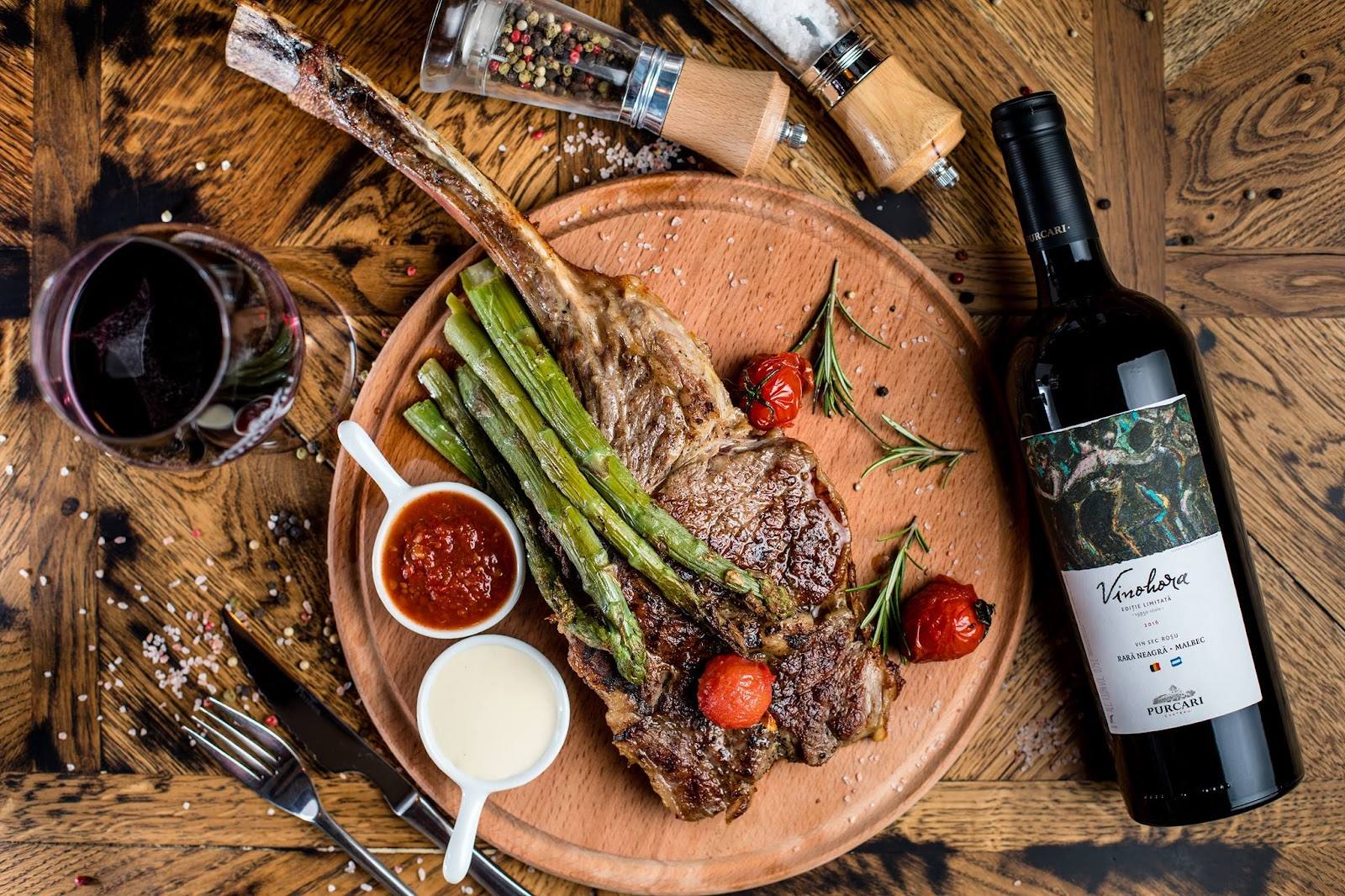 Charcuterie platter with grilled vegetables and red wine on wooden surface