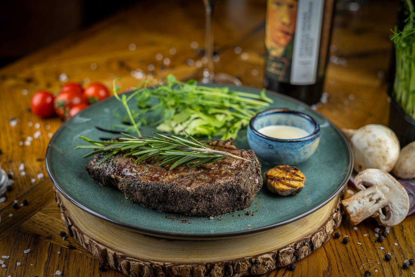 Grilled steak with herbs, mushrooms and sauce on slate plate