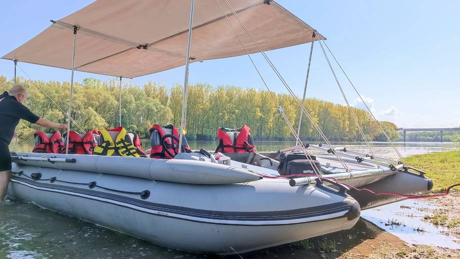 Inflatable boats with canopies ready for water sport activity on riverside beach