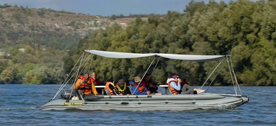 Boat tour group on scenic water with forested hills backdrop