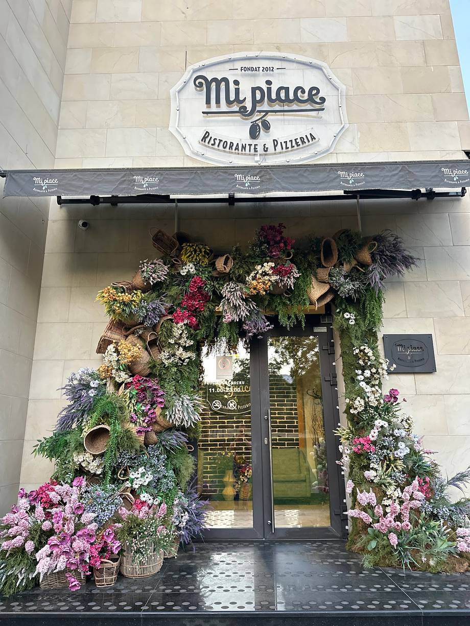 Mt. place restaurant storefront with floral-decorated entrance and signage