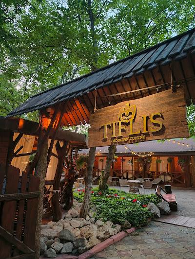 Exterior facade of Telis restaurant with wooden signage and rustic patio entrance area